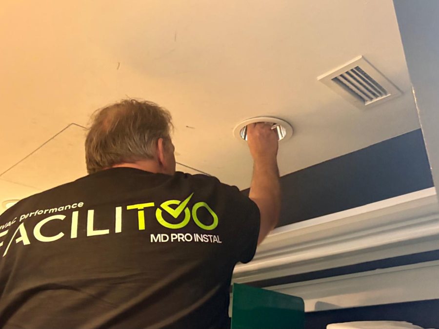Facilitoo technician servicing store ceiling lighting